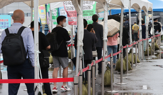 18일 오전 서울역 앞에 마련된 중구 임시선별검사소 앞에서 시민들이 검사를 받기 위해 줄지어 서있다. <연합뉴스>